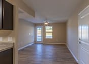 Thumbnail 21 of 55 - A room with wooden floors and a window with blinds.