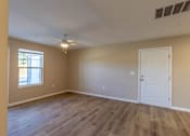 Thumbnail 26 of 55 - A room with a white door and a window with a fan on the ceiling.