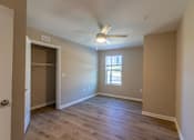 Thumbnail 45 of 55 - A room with a ceiling fan and a door leading to another room.