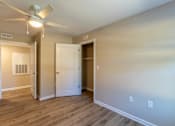 Thumbnail 50 of 55 - A room with a ceiling fan and a door leading to another room.