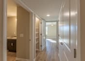 Thumbnail 51 of 55 - A hallway with white doors and a light on the wall.