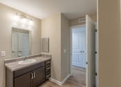 Thumbnail 48 of 55 - A bathroom with a sink, mirror, and lighting fixture.