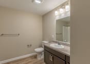 Thumbnail 47 of 55 - A bathroom with a toilet, sink, and mirror.