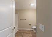 Thumbnail 31 of 55 - A white door is open to a small bathroom with a toilet and a sink.