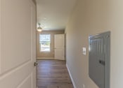 Thumbnail 33 of 55 - A long hallway with a door on the left and a window on the right.