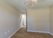 Thumbnail 32 of 55 - A long, empty hallway with a door at the end.