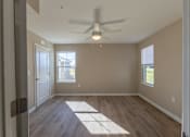 Thumbnail 34 of 55 - A room with a ceiling fan and wooden flooring.