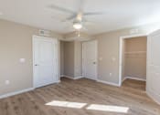 Thumbnail 40 of 55 - A room with a ceiling fan and wooden flooring.