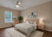 Thumbnail 30 of 31 - A bedroom with a large bed, a ceiling fan, and two nightstands.