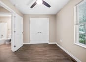 Thumbnail 4 of 72 - an empty bedroom with a ceiling fan and a door to the bathroom