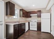 Thumbnail 15 of 72 - a kitchen with dark cabinets and a white refrigerator