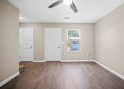 Thumbnail 19 of 72 - an empty living room with white doors and a ceiling fan