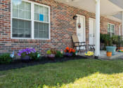 Thumbnail 47 of 72 - the front porch of a brick house with flowers and a chair
