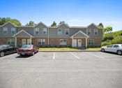 Thumbnail 61 of 72 - a parking lot in front of a large apartment building with cars parked