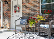 Thumbnail 66 of 72 - a front porch with chairs and flowers and a cat on the ground