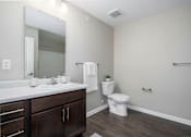 Thumbnail 24 of 25 - A bathroom with a white toilet and a white sink.