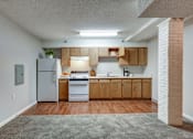 Thumbnail 20 of 22 - A kitchen with wooden cabinets and a white refrigerator.
