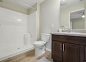 Thumbnail 22 of 22 - A white toilet sits in a bathroom next to a white bathtub.