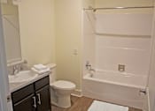 Thumbnail 25 of 25 - A white bathroom with a toilet, sink, and bathtub.