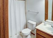 Thumbnail 27 of 28 - A white toilet sits next to a white sink in a bathroom.