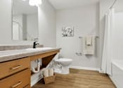 Thumbnail 57 of 57 - A white bathroom with a toilet, sink, and a white shower curtain.