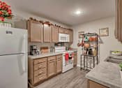Thumbnail 26 of 29 - A kitchen with wooden cabinets and a white refrigerator.