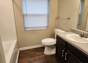 Thumbnail 5 of 30 - A white toilet sits in a bathroom next to a sink.