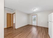 Thumbnail 48 of 64 - A room with wooden floors and a white refrigerator.