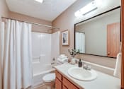 Thumbnail 25 of 27 - A bathroom with a white toilet, sink, and shower curtain.