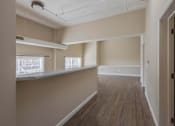 Thumbnail 32 of 39 - A long, empty hallway with wooden floors and white walls.