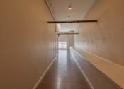 Thumbnail 24 of 39 - A long hallway with a door at the end.