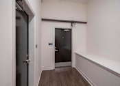 Thumbnail 31 of 39 - A hallway with a door at the end and a wall on the right.