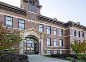 Thumbnail 28 of 39 - A large brick building with a large arched entrance.
