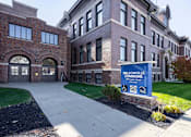Thumbnail 25 of 39 - Nelsonville Commons is a large brick building with a sign in front of it.