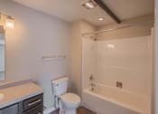Thumbnail 21 of 39 - A white toilet sits next to a bathtub in a bathroom.