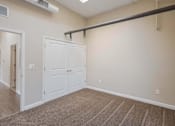 Thumbnail 19 of 39 - A room with a white door and a brown carpet.