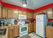 Thumbnail 20 of 20 - A kitchen with wooden cabinets and a white refrigerator.