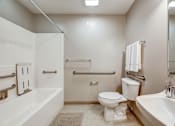 Thumbnail 27 of 27 - A white bathroom with a toilet, sink, and bathtub.