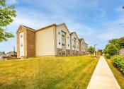 Thumbnail 18 of 48 - a row of apartment buildings on a grassy hill