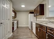 Thumbnail 7 of 35 - A kitchen with white appliances and wooden cabinets.
