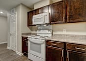 Thumbnail 6 of 35 - A kitchen with a white oven and microwave above a stove.