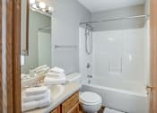 Thumbnail 27 of 28 - A white toilet sits next to a white bathtub in a bathroom.