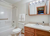 Thumbnail 24 of 25 - A white toilet sits next to a sink in a bathroom.