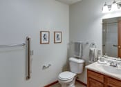 Thumbnail 31 of 31 - A white toilet sits in a bathroom next to a sink and a shower.