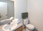Thumbnail 51 of 51 - A white toilet sits next to a sink in a bathroom.