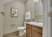 Thumbnail 6 of 9 - A white toilet sits in a bathroom next to a sink.