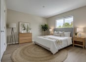 Thumbnail 7 of 9 - A bedroom with a large bed, a nightstand, and a rug on the floor.
