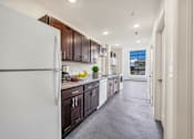 Thumbnail 50 of 51 - A modern kitchen with dark brown cabinets and a white refrigerator.