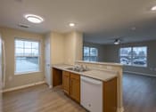 Thumbnail 4 of 37 - A kitchen with wooden cabinets and a white dishwasher.