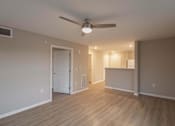 Thumbnail 7 of 37 - A room with a ceiling fan and light fixture, and a door leading to another room.